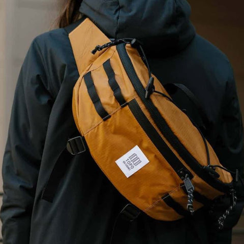 TOPO DESIGNS MOUNTAIN SLING BAG BOASTS A SPACIOUS MAIN COMPARTMENT AND SMALLER POCKETS